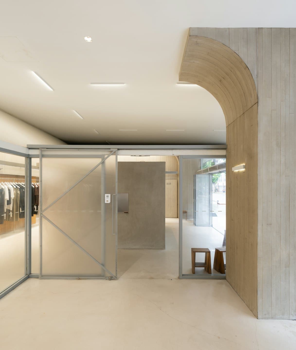 Beton duvarlı ve giysi raflı modern perakende mağazası.